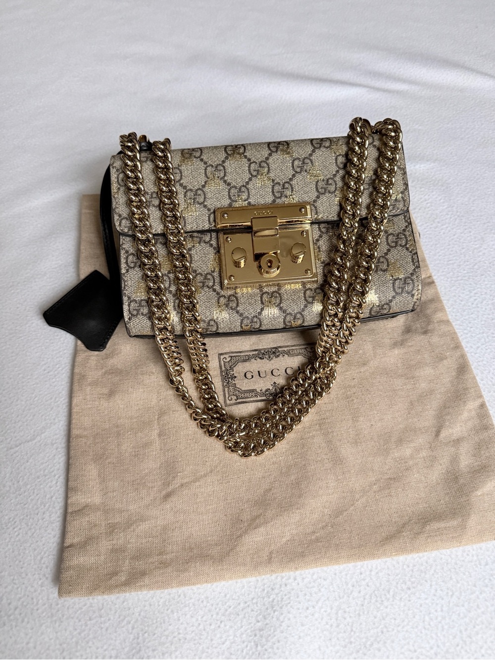 Gucci Beige GG Supreme Chain Shoulder Bag with Gold Hardware and lock keys.